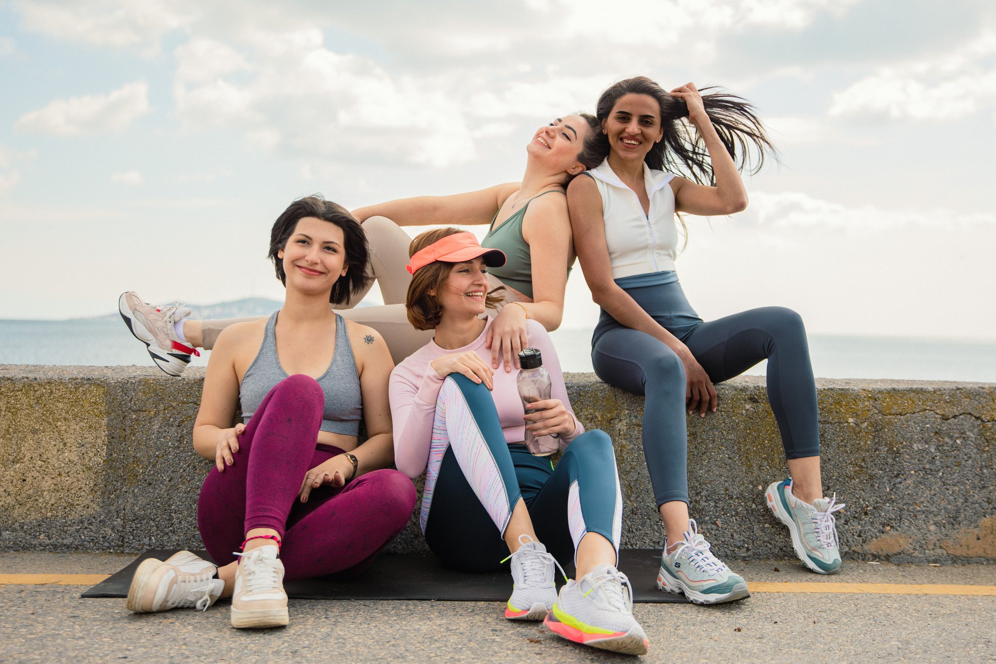 Many women in yoga clothes smiling and looking at the camera